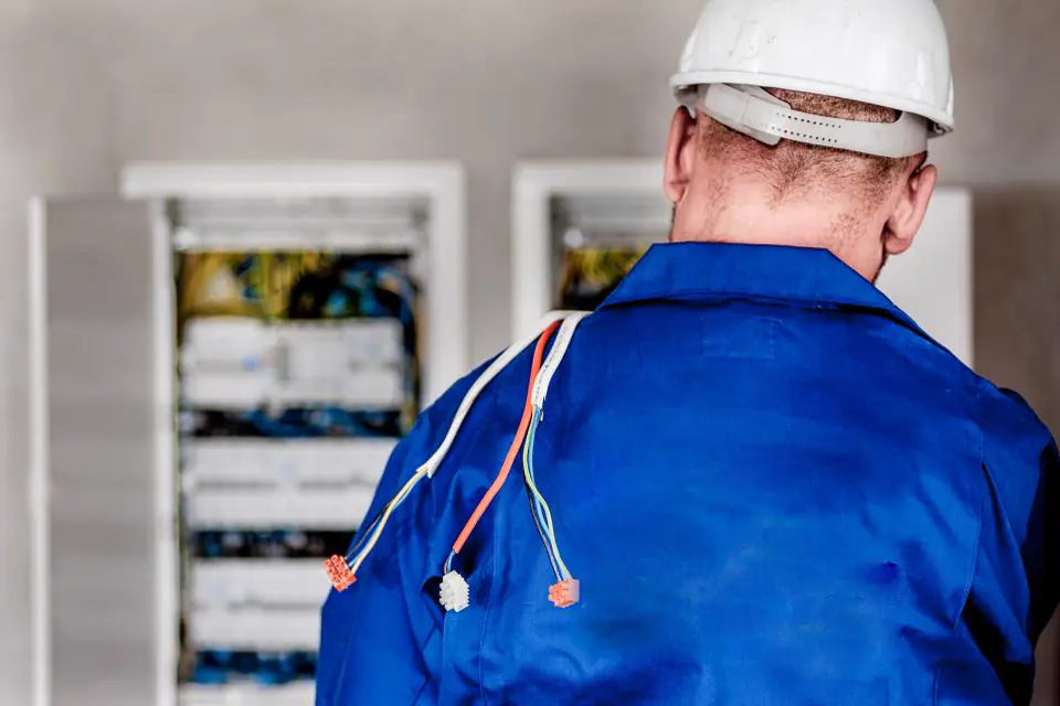 Electrician in front of open distribution boards